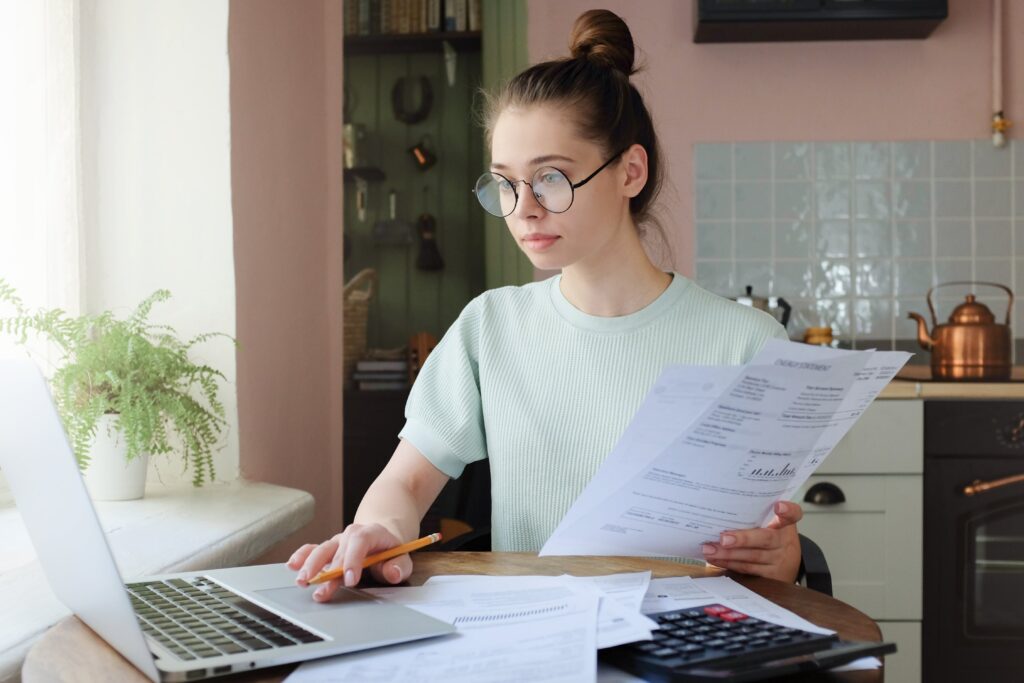 Woman sitting in front of her laptop with papers