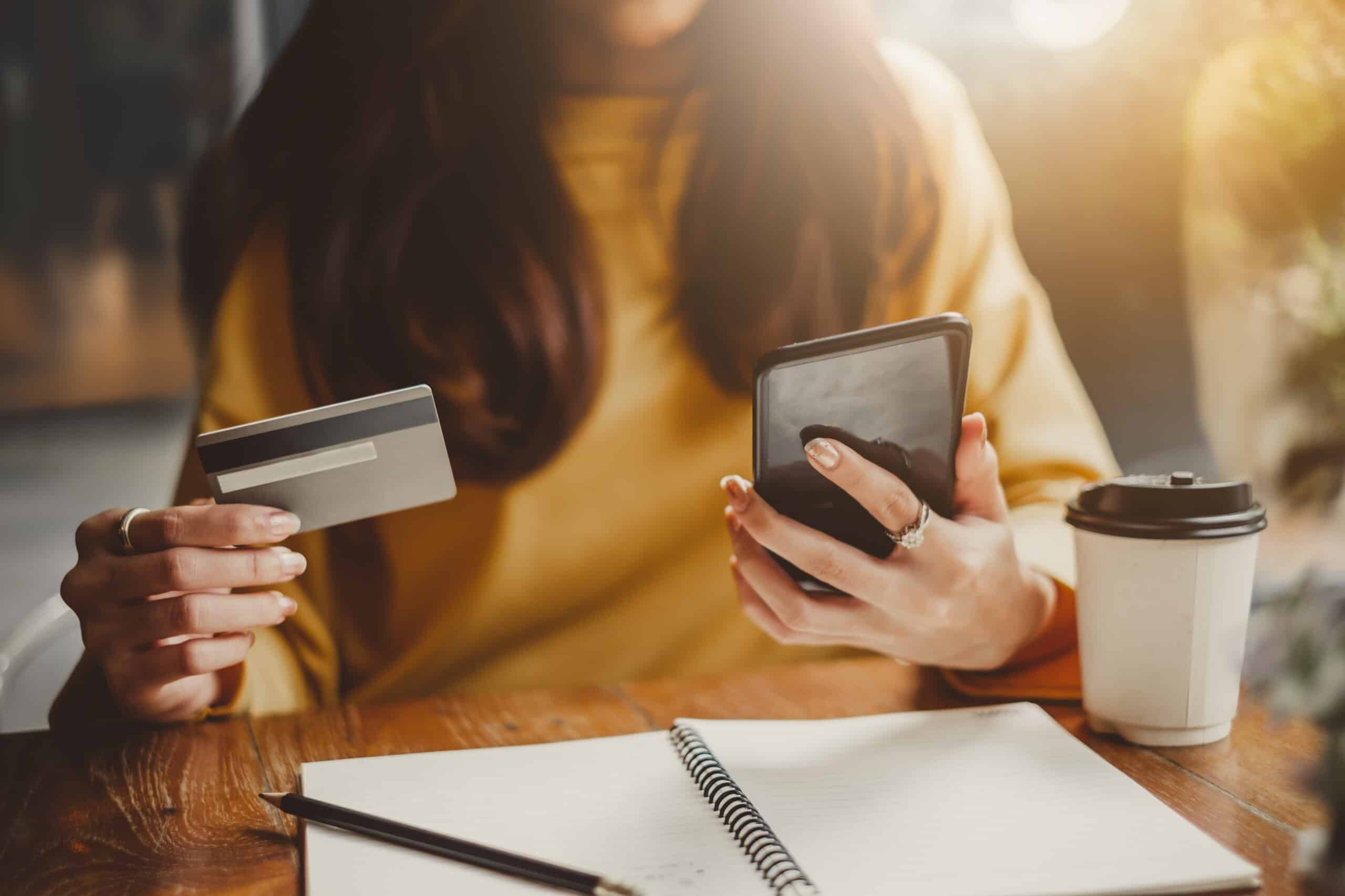 Woman looking at her credit card and phone