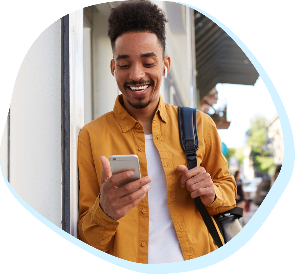 Younger black man in a yellow shirt looking at his phone