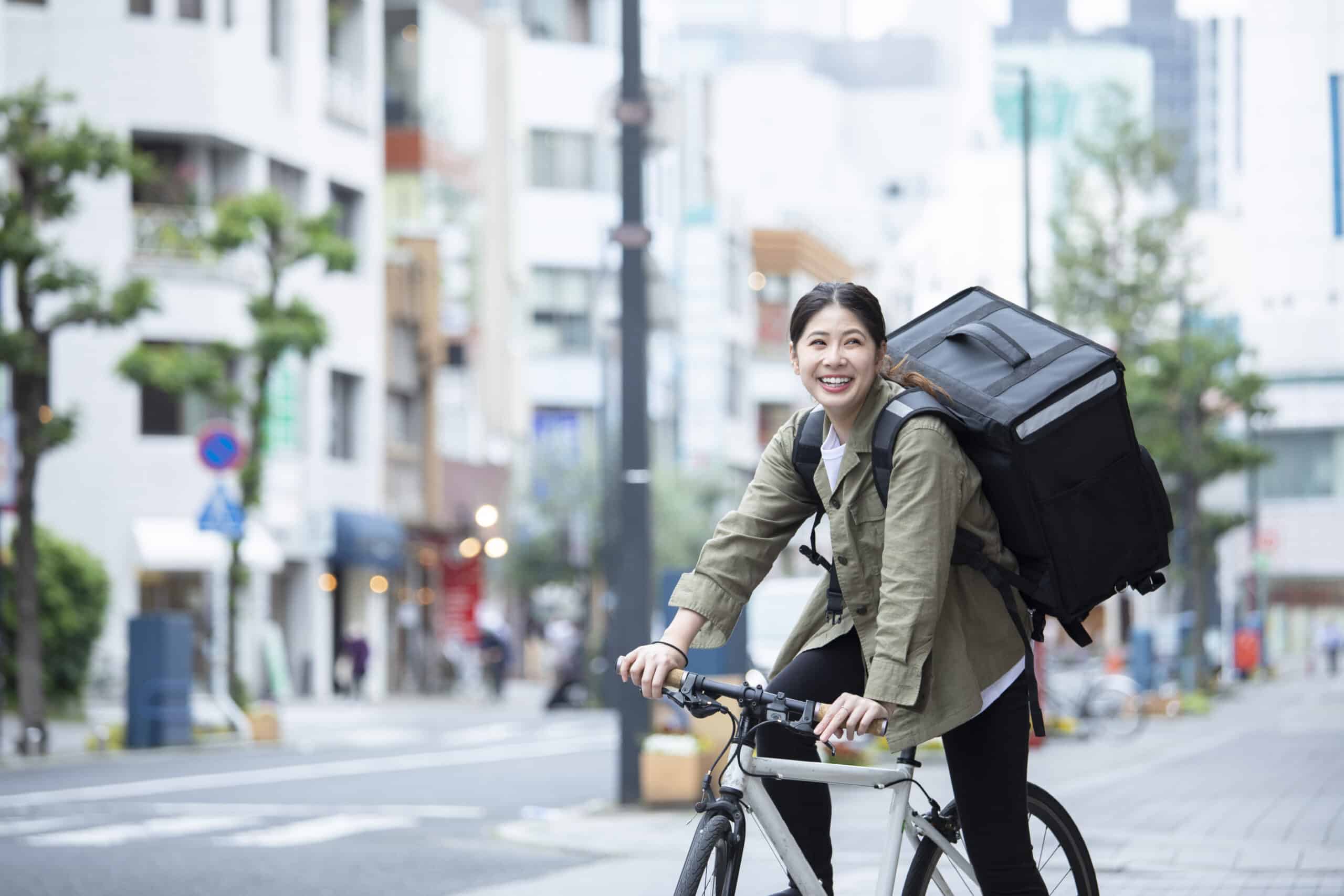 Young woman doing luggage delivery by bicycle