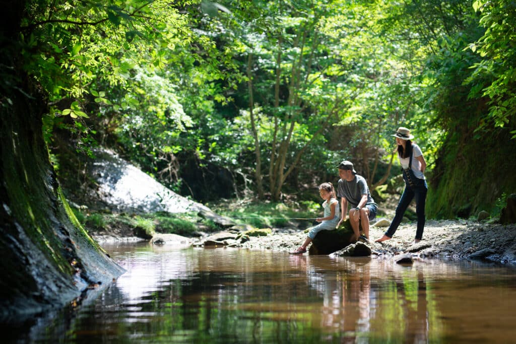 Father and mother and daughter fishing outdoors. Affordable summer vacation