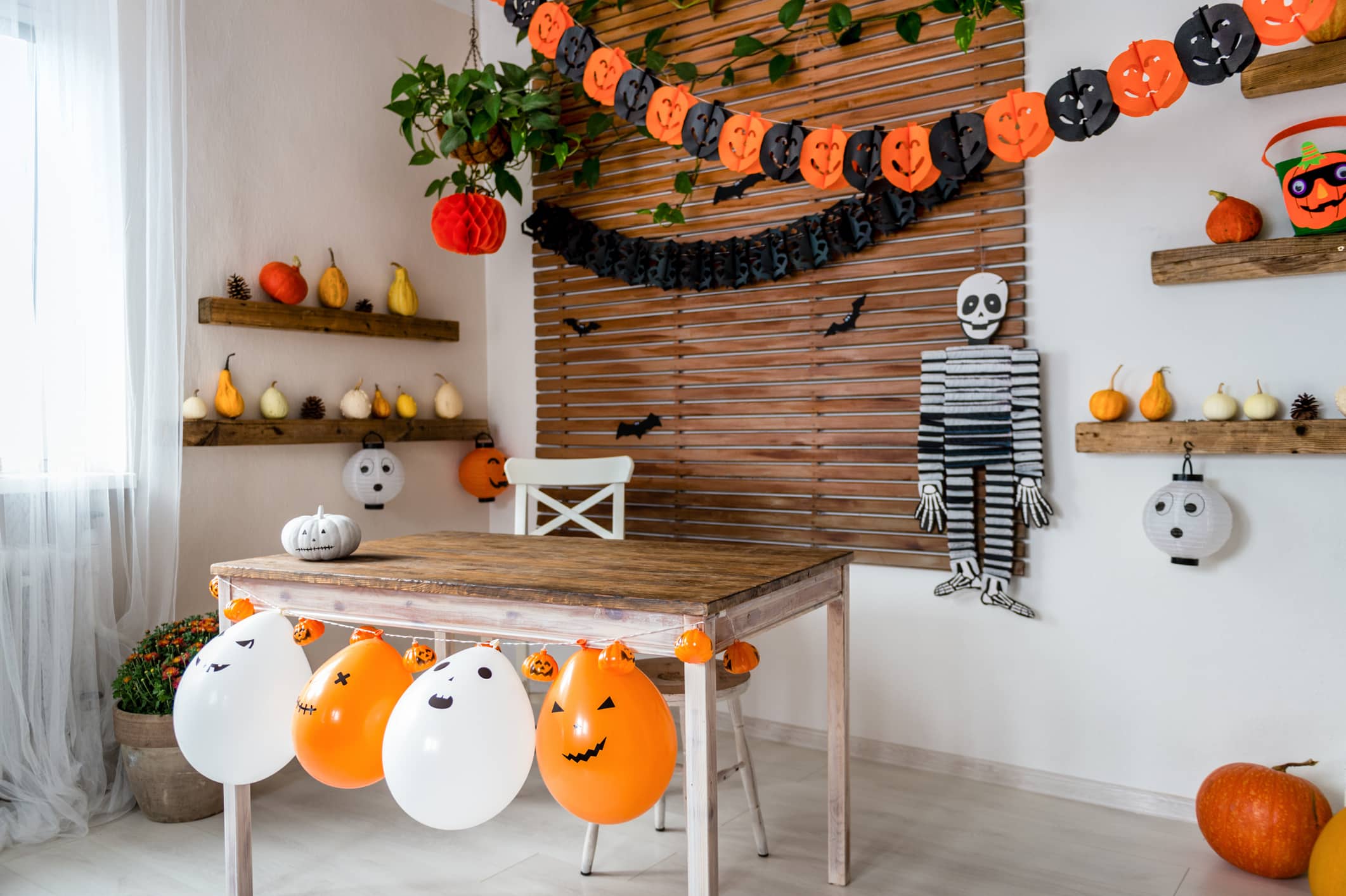 how to decorate for Halloween on a budget. Halloween theme decorated living room. Lifestyle Halloween season family house interior. Traditional Halloween decorations background.