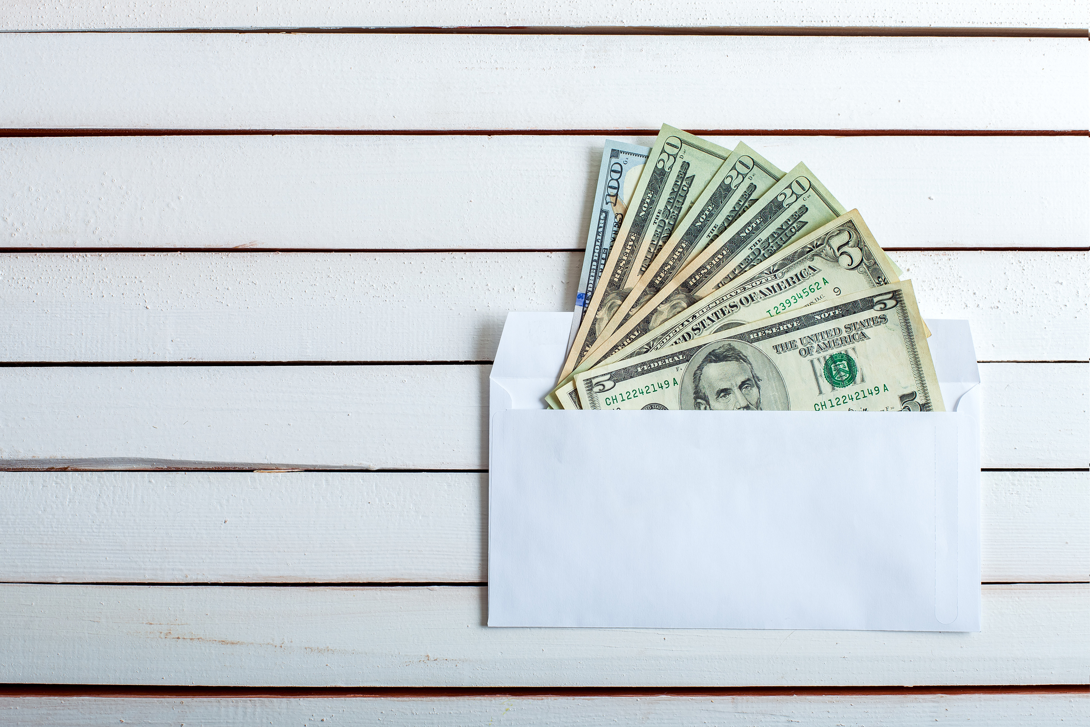 cash stuffing. Cash in an envelope, the denomination on a table from white wooden boards.
