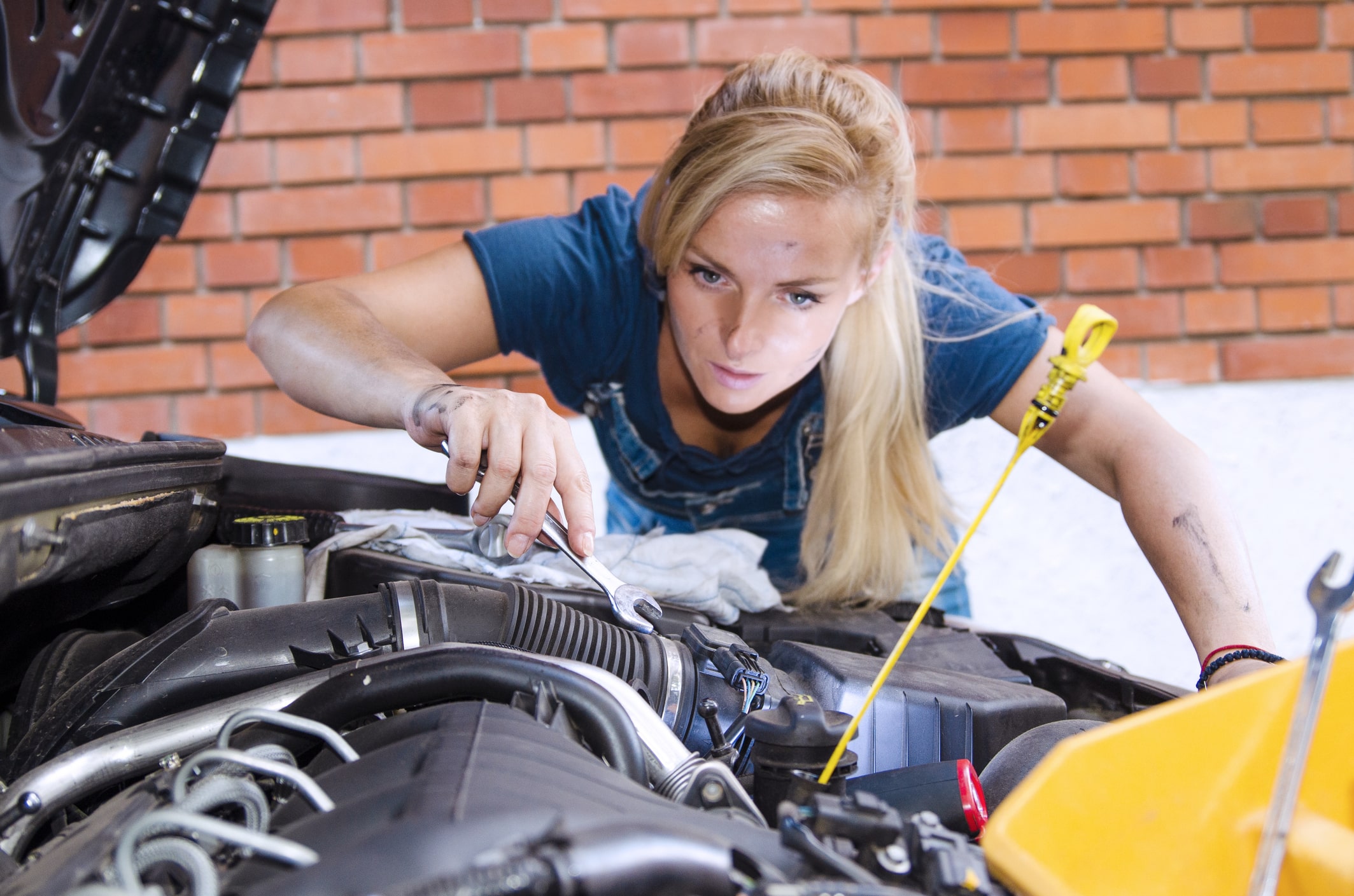 winter car maintenance. Woman repairing the Car engine using wrench.Woman Mechanic on work selective focus.