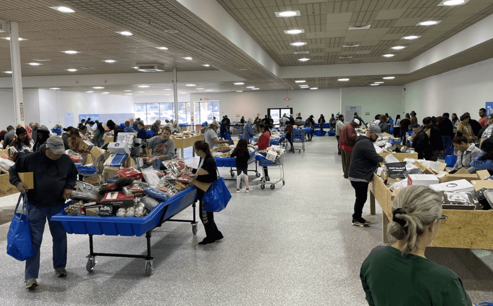 Bin store. Aisles and people sorting through items in bins, on tables.