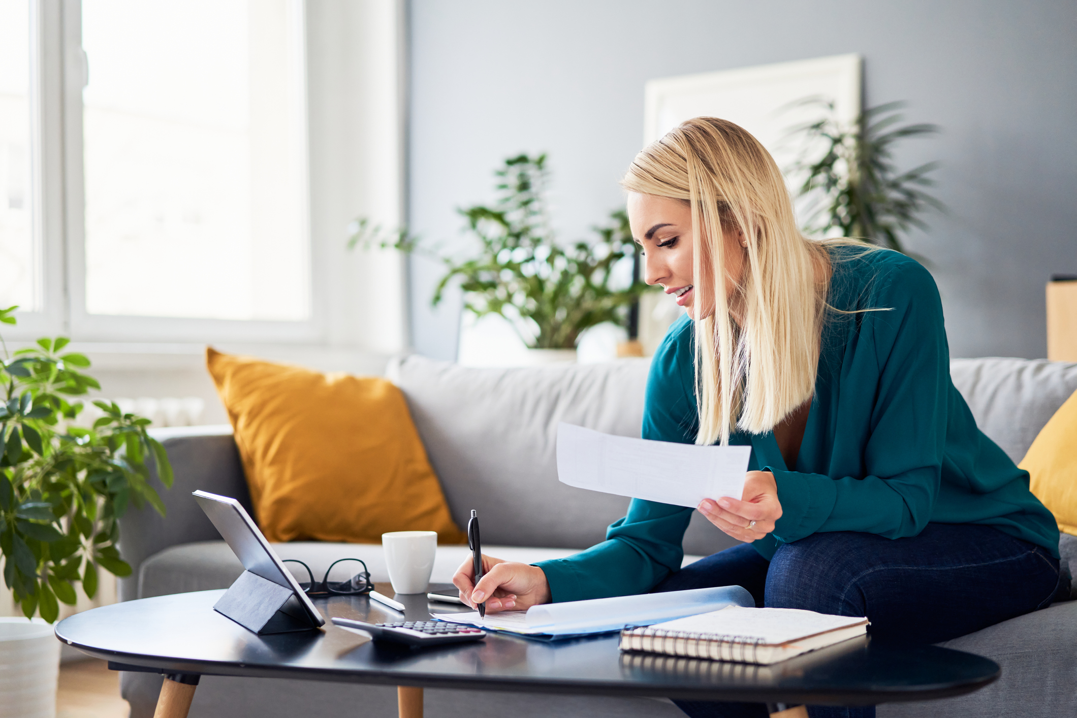 woman in green sweater sitting at computer comparing types of budgets