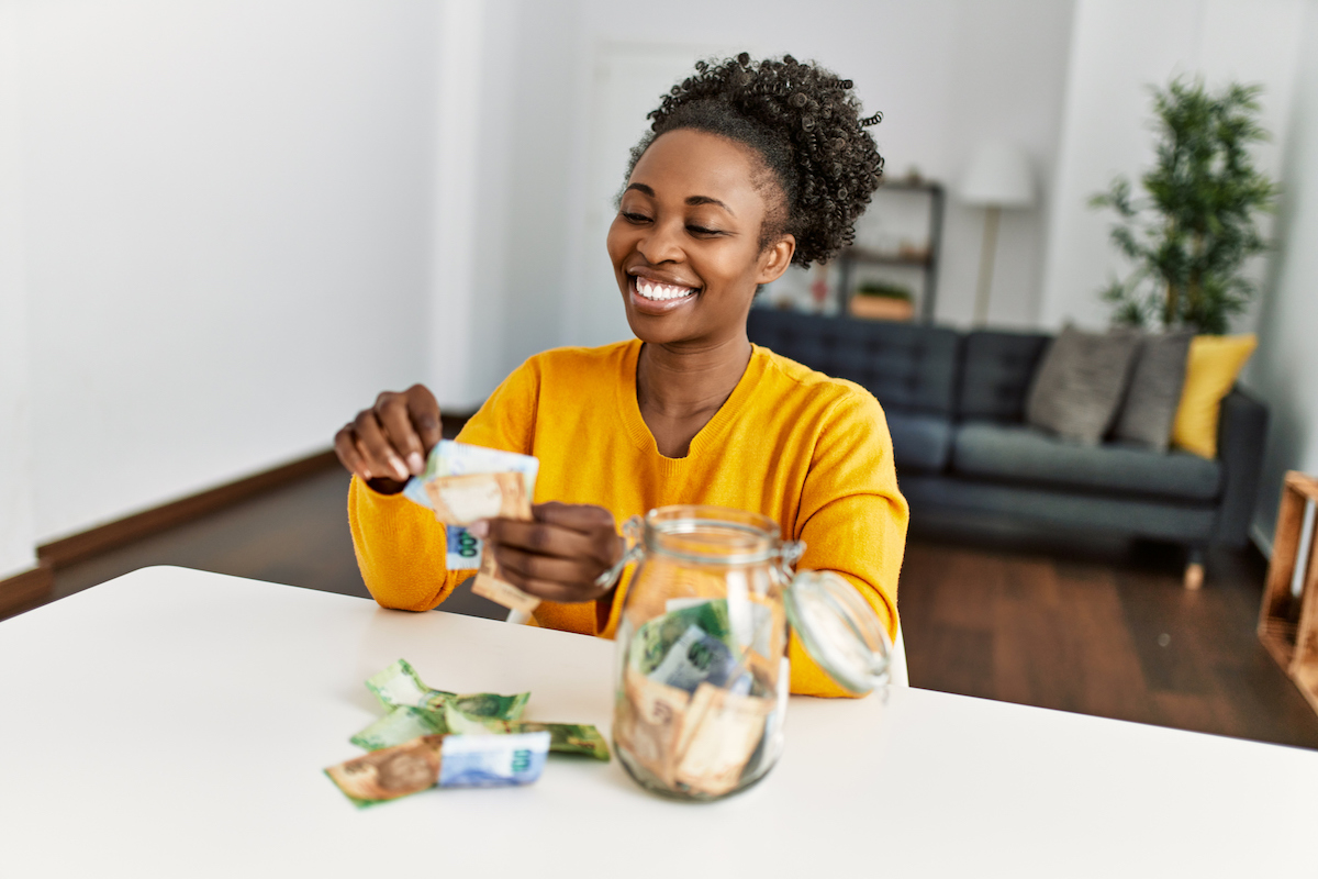 quick tips to save mone. Smiling woman holding cash.