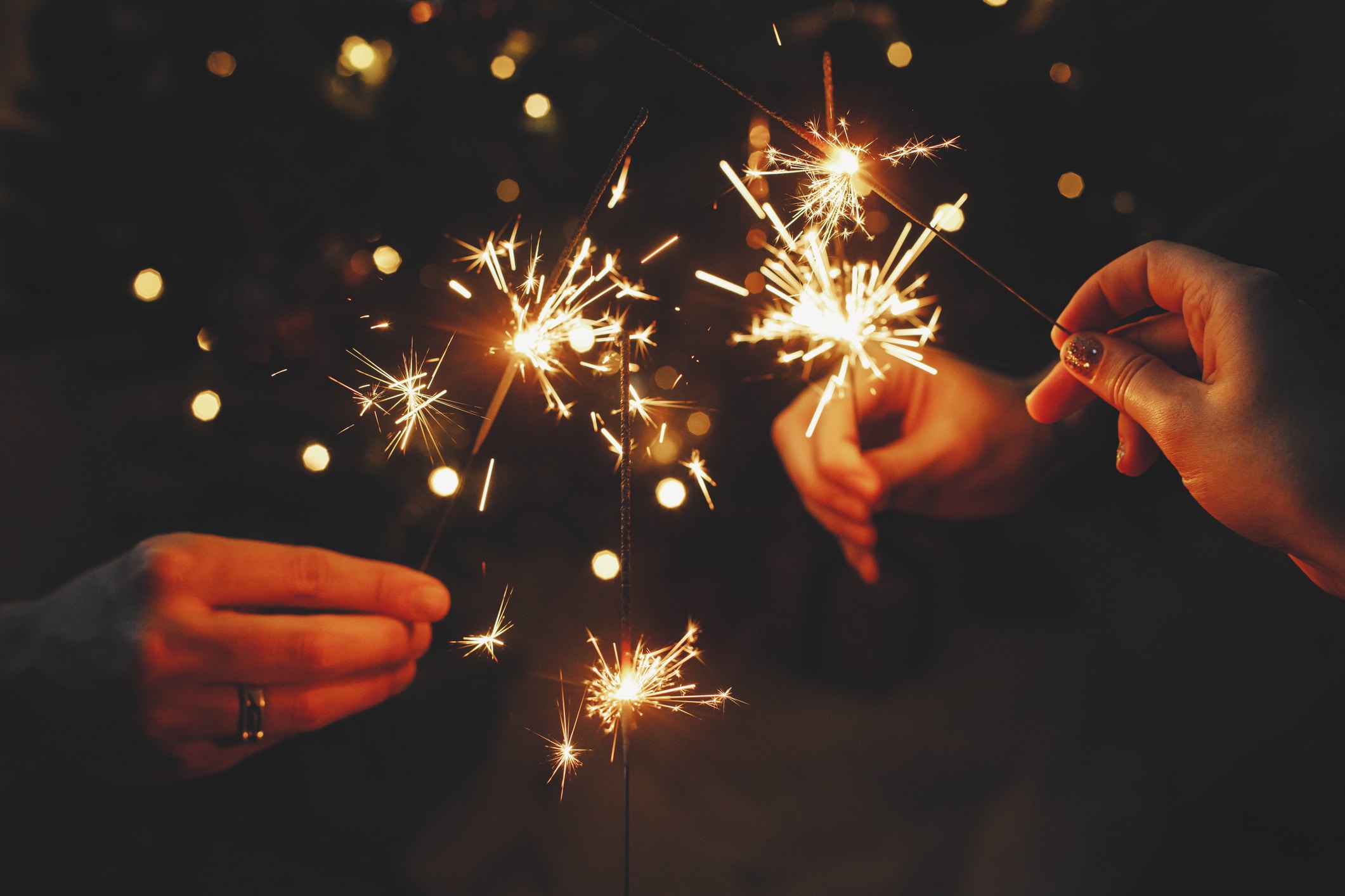 New Year's resolutions, friends celebrating with sparklers in hands.