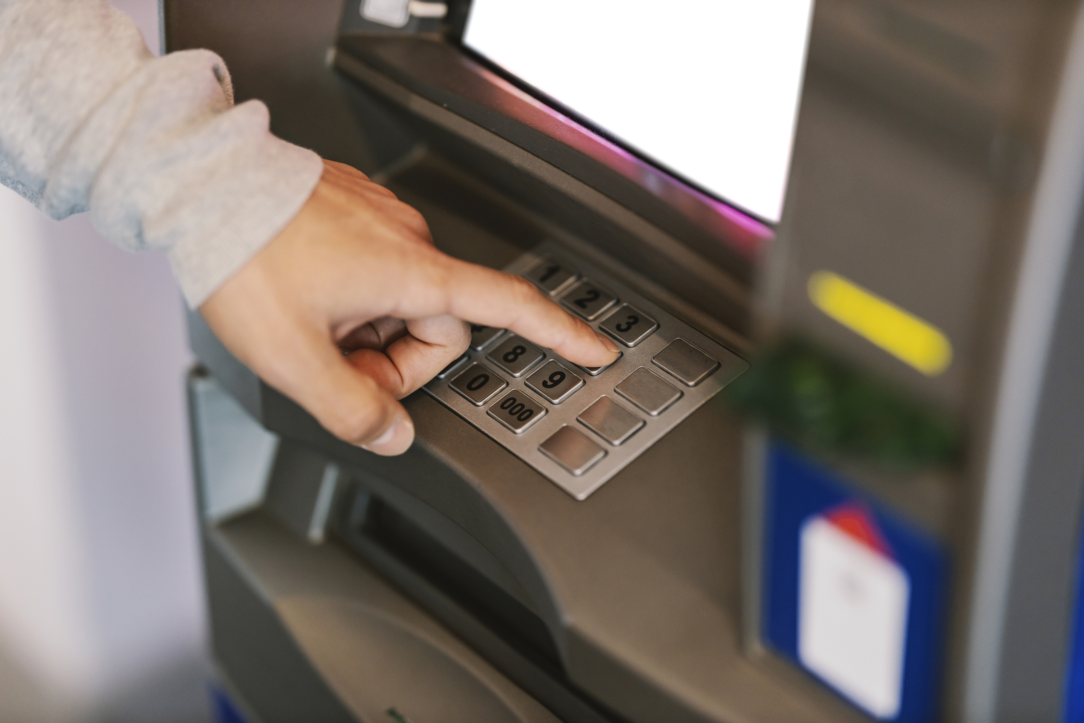 Credit unions. A customer's hands typing PIN on ATM.