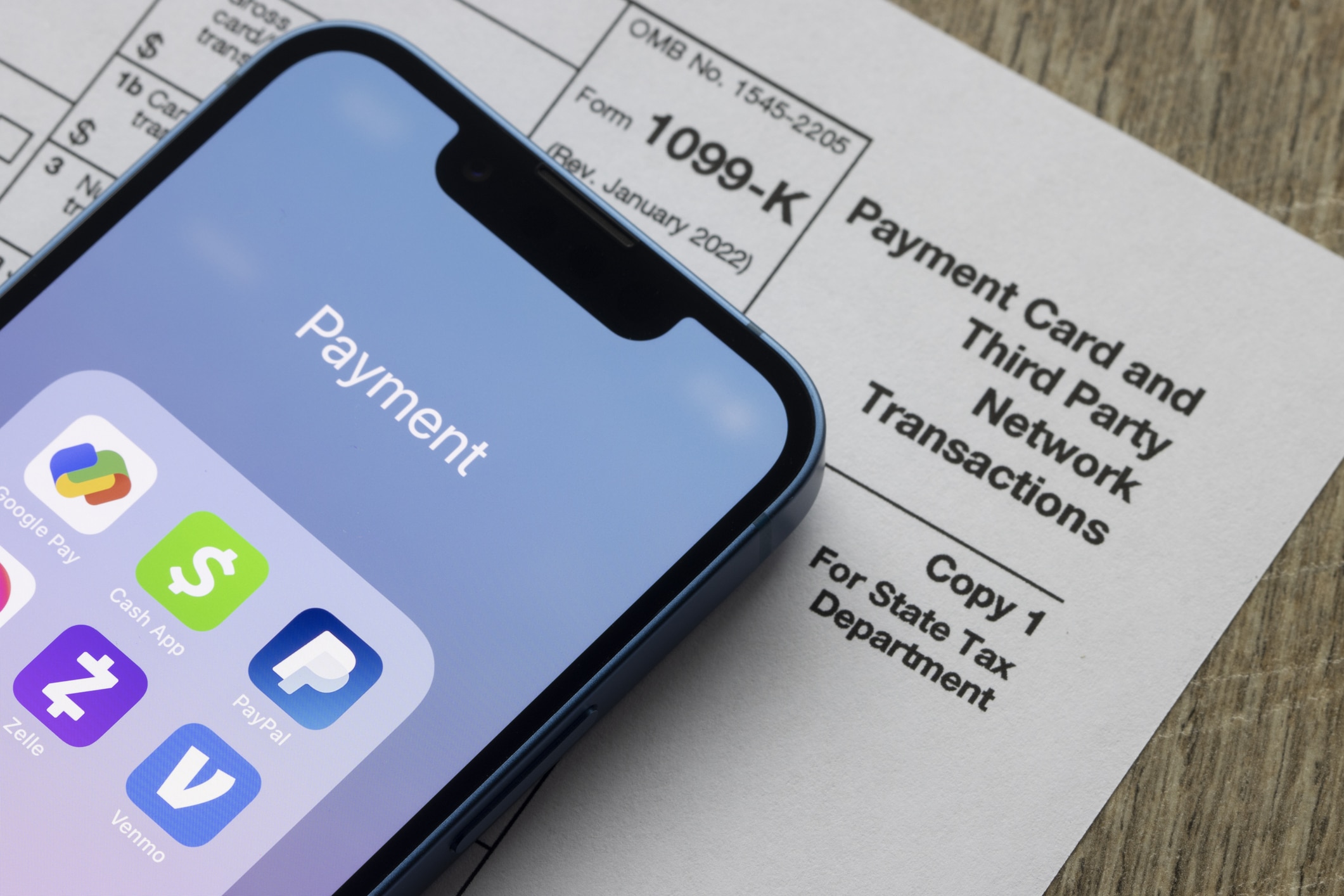 cash app assortment—like PayPal and Venmo are seen on an iPhone on top of Form 1099-k. Third-party payment apps now have to report transactions more than USD600 to the IRS.