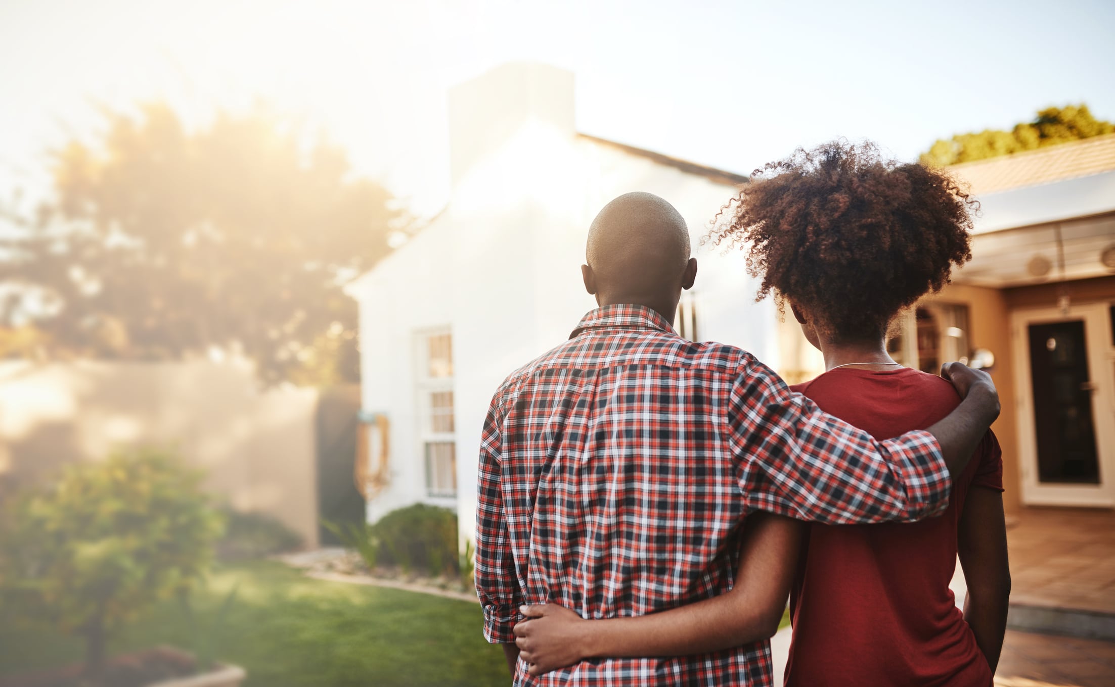 credit score to buy a home. Back view, black couple and hug outdoor at house, real estate and new loan for luxury home. Man, woman and people in front of property investment, moving and dream neighborhood for building mortgage