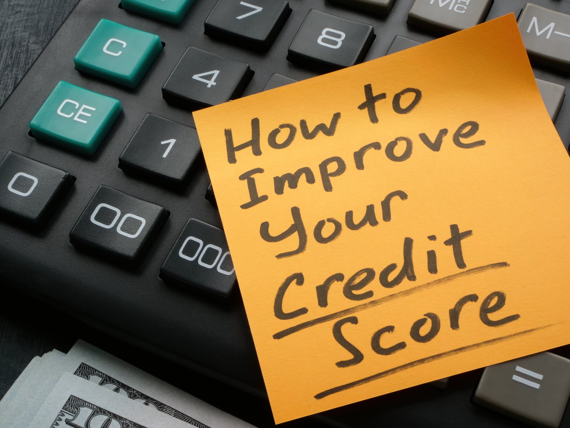 raise your credit score. A Memo stick with How to improve your credit score inscription on the calculator.