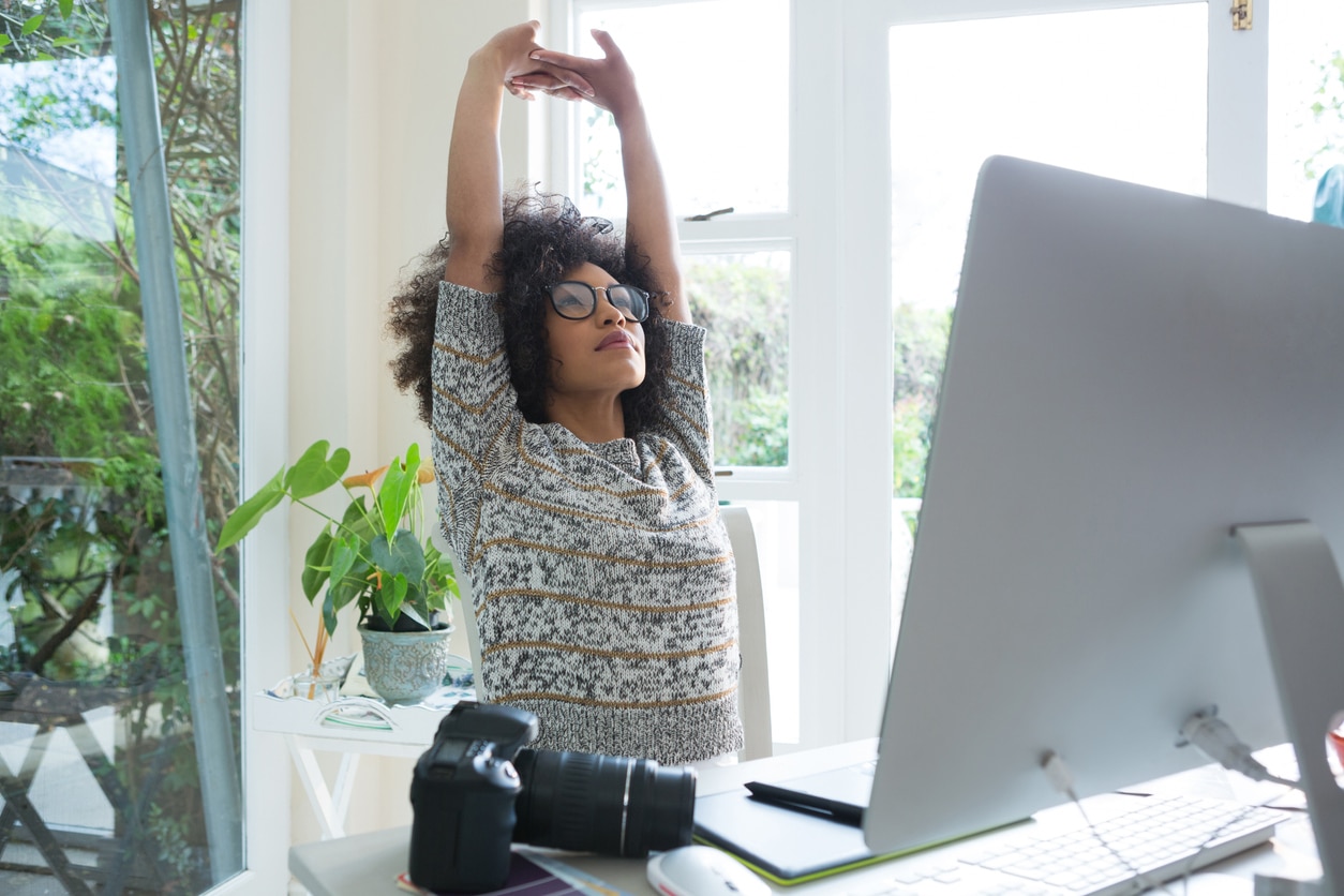 health hacks, woman stretching at her desk