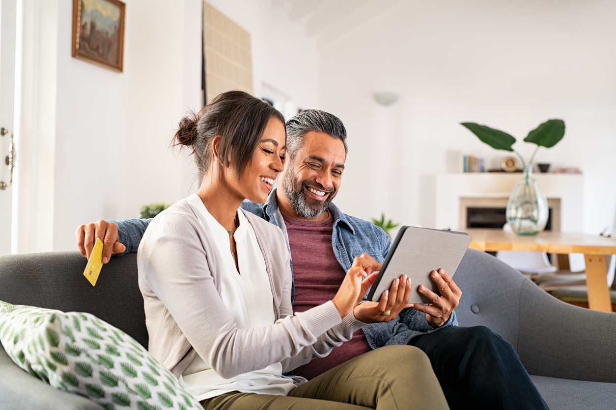 couple looking at money management apps on tablet.