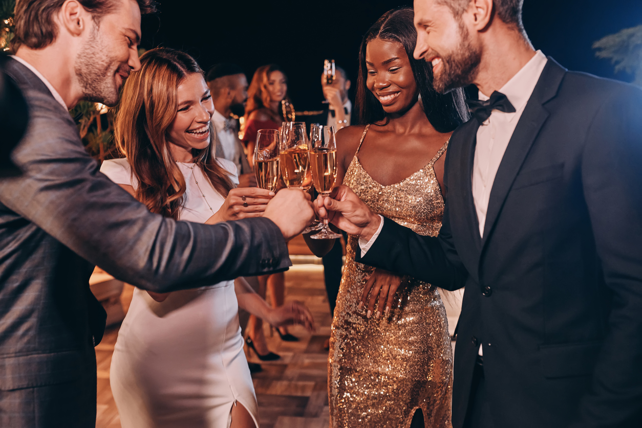 wedding guest group at a celebration, two men and two women with champagne.